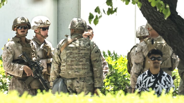 Army veteran Marcos Leao kneels while being detained by Marines at the Wilshire federal building on June 13, 2025.